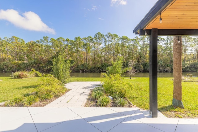 view of yard with a water view and a patio area