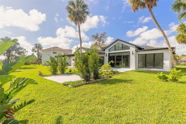 back of property featuring a patio area and a yard