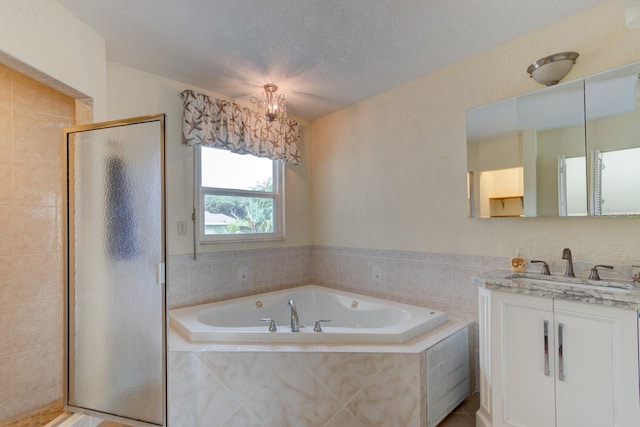 bathroom with vanity, separate shower and tub, and a textured ceiling