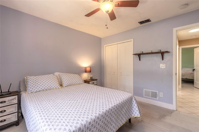 tiled bedroom with ceiling fan and a closet