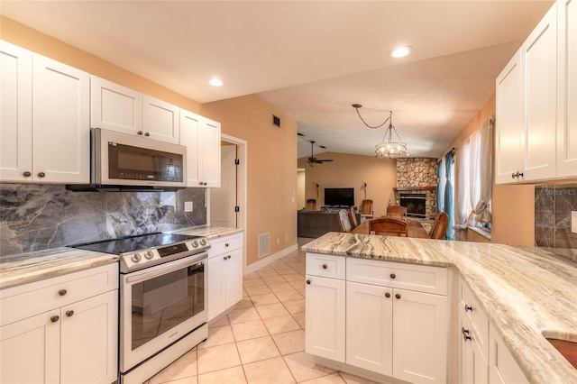 kitchen featuring white cabinetry, a stone fireplace, ceiling fan, and appliances with stainless steel finishes