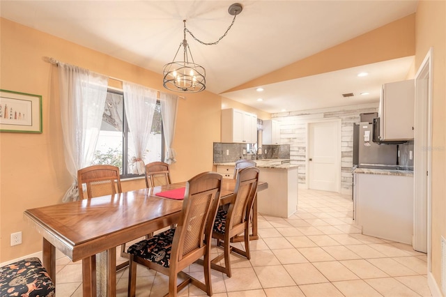 tiled dining room featuring sink, lofted ceiling, and a notable chandelier