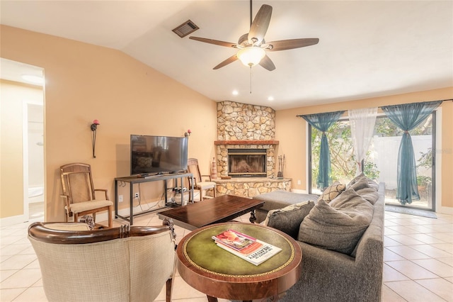 living room featuring ceiling fan, a stone fireplace, light tile patterned floors, and vaulted ceiling