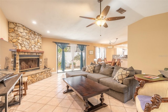 tiled living room featuring a fireplace, ceiling fan with notable chandelier, and vaulted ceiling