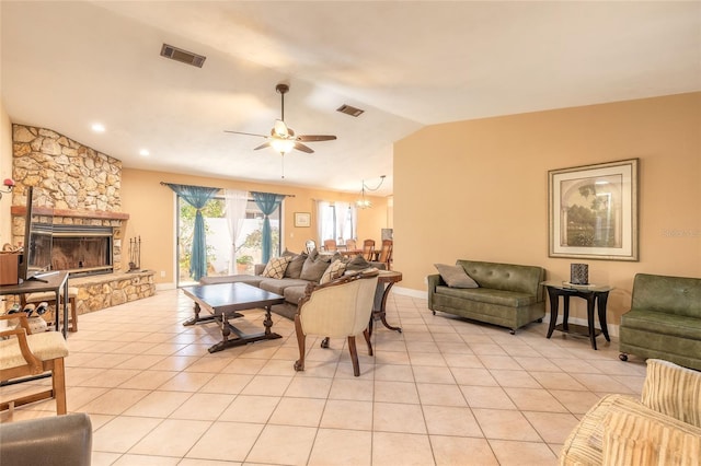 tiled living room featuring ceiling fan, a stone fireplace, and lofted ceiling