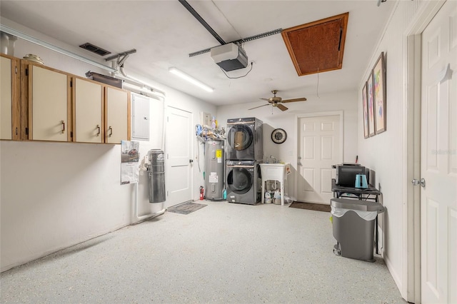 garage with electric panel, a garage door opener, ceiling fan, water heater, and stacked washer / dryer