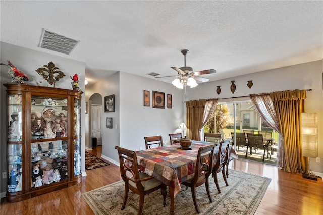 dining room featuring a textured ceiling, light hardwood / wood-style floors, and ceiling fan