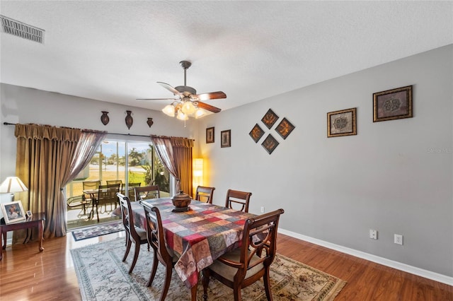 dining space featuring hardwood / wood-style flooring, ceiling fan, and a textured ceiling