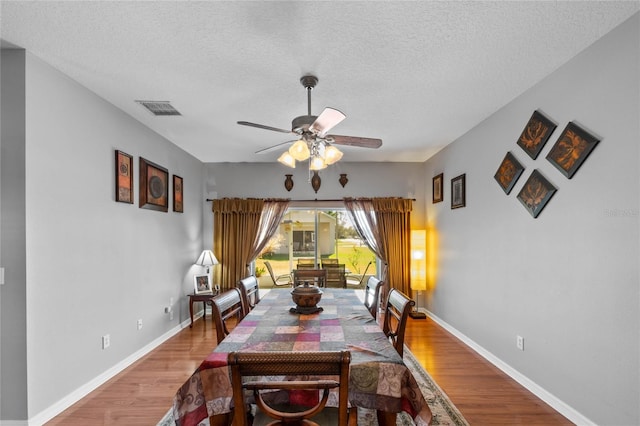 dining space with a textured ceiling, hardwood / wood-style flooring, and ceiling fan