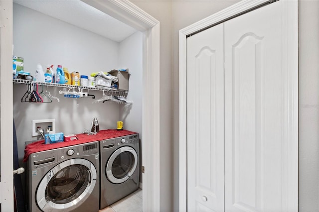 clothes washing area featuring light tile patterned floors and independent washer and dryer