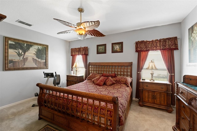 bedroom featuring multiple windows, ceiling fan, and light carpet