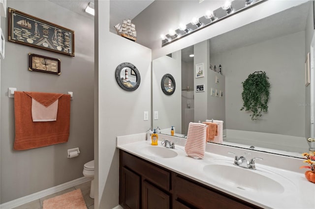 bathroom with tile patterned flooring, vanity, and toilet