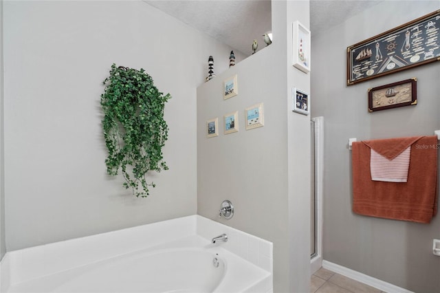 bathroom featuring tile patterned flooring, a textured ceiling, and plus walk in shower