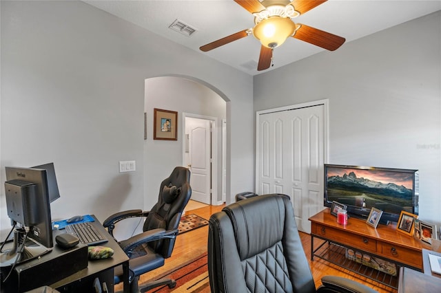 home office with light wood-type flooring and ceiling fan