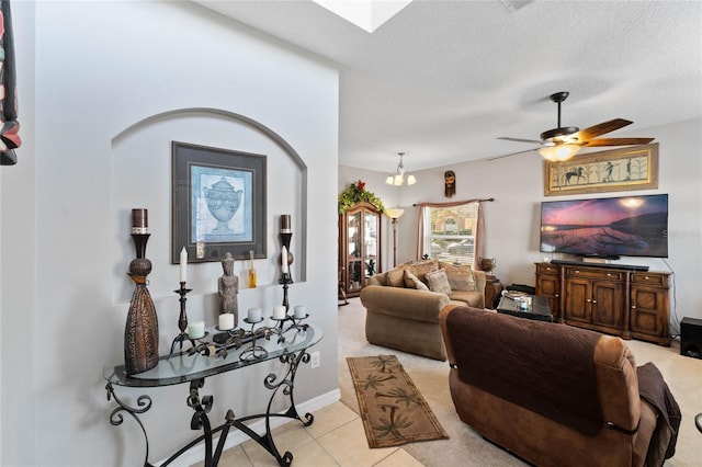 tiled living room with ceiling fan with notable chandelier and a textured ceiling