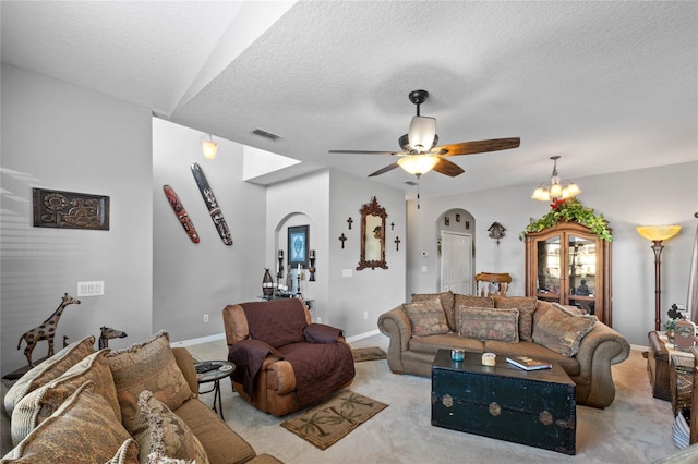 living room with a textured ceiling, ceiling fan with notable chandelier, and light colored carpet