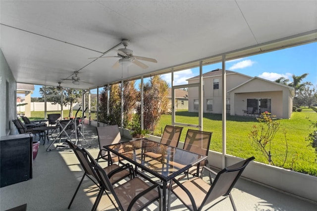 unfurnished sunroom featuring ceiling fan