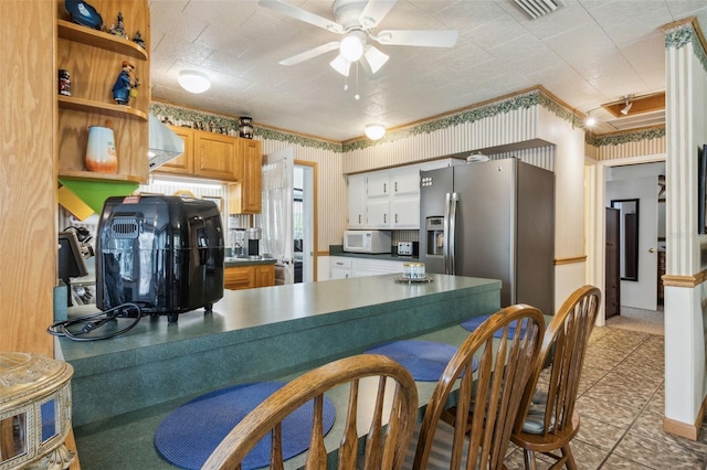 kitchen with stainless steel refrigerator with ice dispenser, kitchen peninsula, and ceiling fan