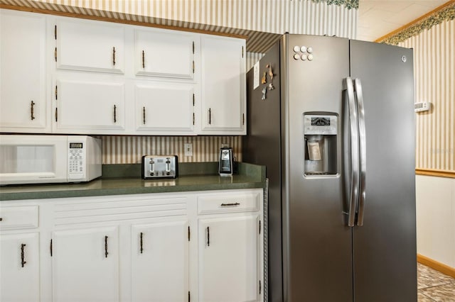 kitchen featuring white cabinetry and stainless steel fridge