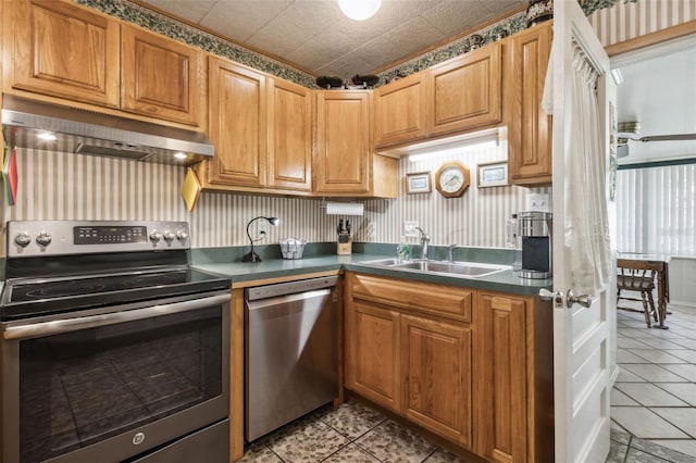 kitchen featuring light tile patterned floors, stainless steel appliances, and sink