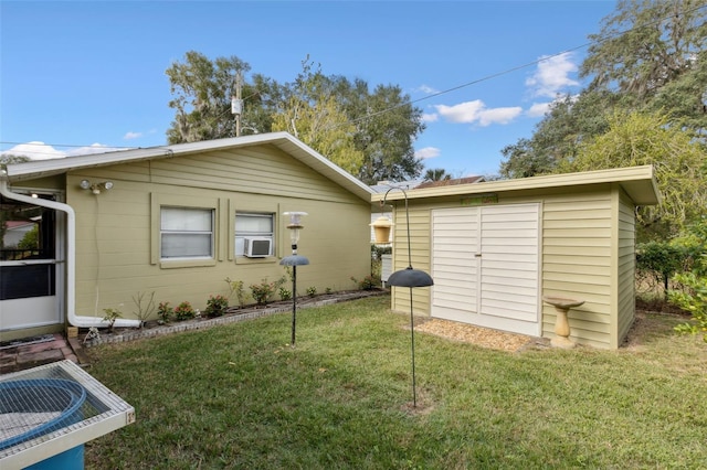 rear view of property with cooling unit, a lawn, and a shed