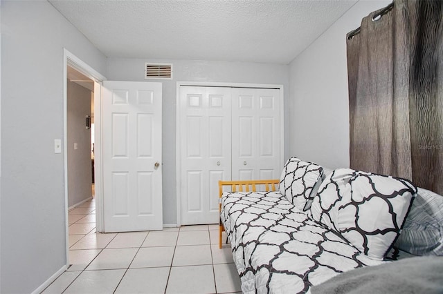 1571 S Boundary St, Deland, FL 32720 - bedroom featuring light tile patterned floors, a textured ceiling, a closet, and baseboards