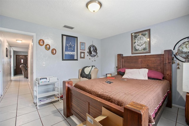 bedroom with light tile patterned flooring and a textured ceiling