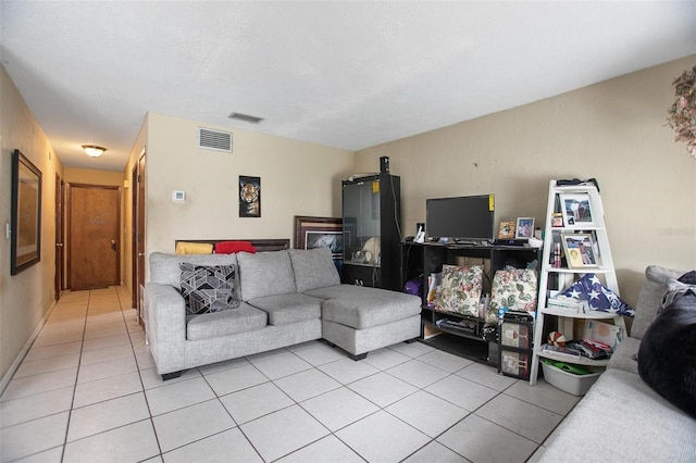 living room with light tile patterned flooring and a textured ceiling