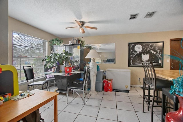 dining space with light tile patterned floors, a textured ceiling, and ceiling fan