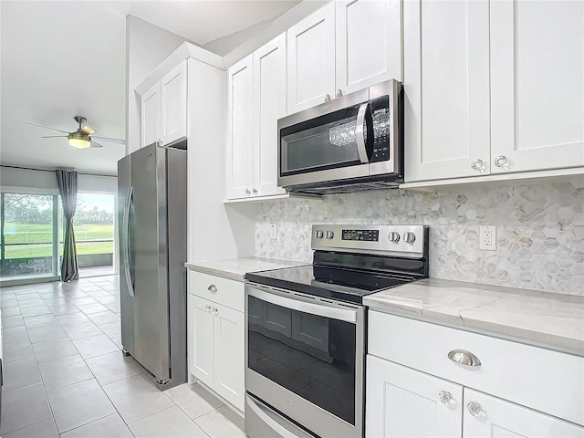 kitchen featuring light stone counters, stainless steel appliances, ceiling fan, white cabinets, and light tile patterned flooring