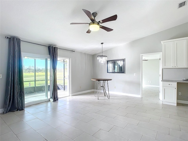 interior space featuring ceiling fan with notable chandelier, light tile patterned floors, and vaulted ceiling