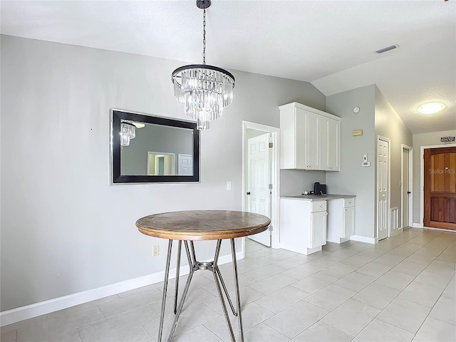 unfurnished dining area with lofted ceiling, a textured ceiling, light tile patterned floors, and a chandelier