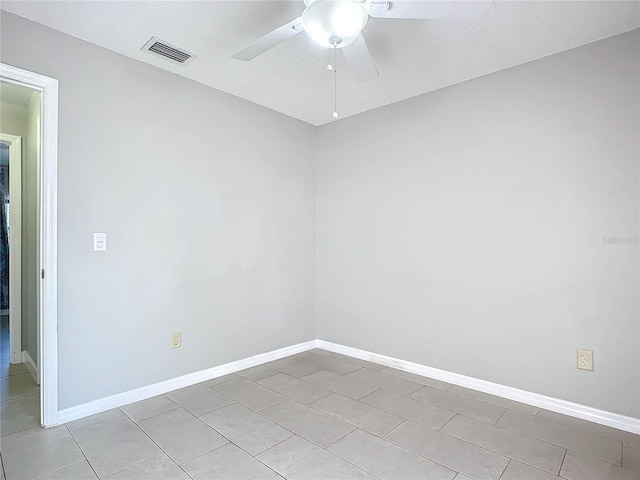 tiled spare room with ceiling fan