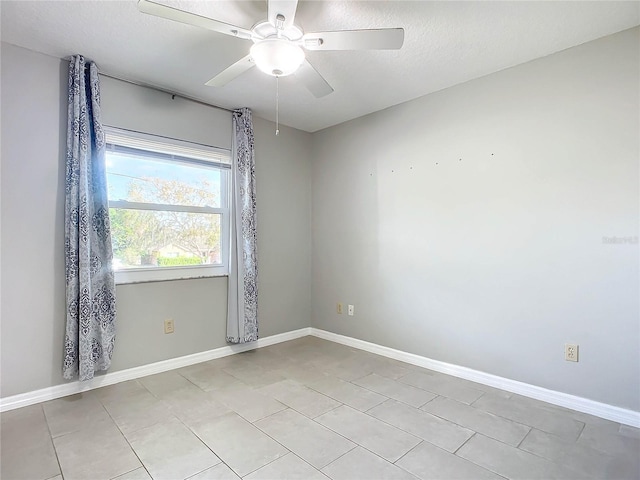 empty room with light tile patterned floors, a textured ceiling, and ceiling fan