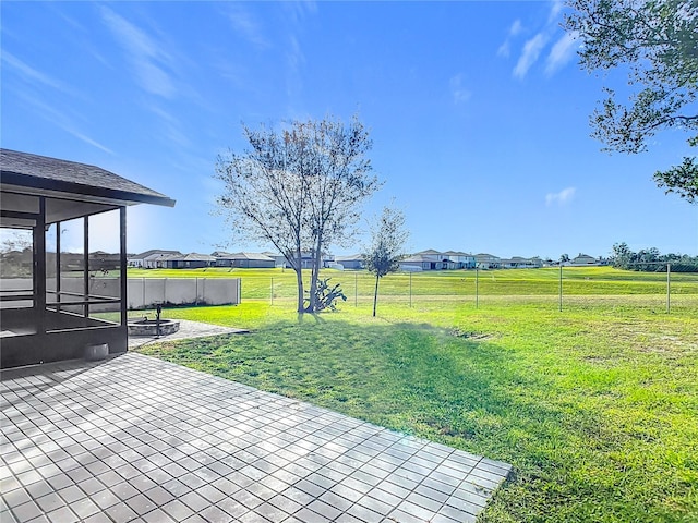 view of yard with a sunroom and a patio