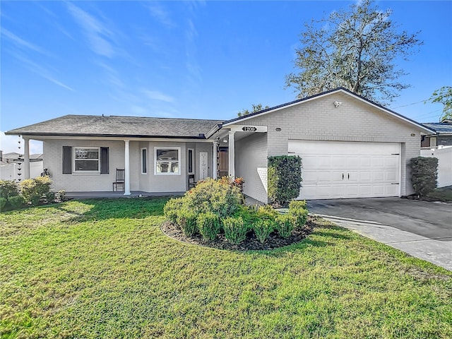 ranch-style home featuring covered porch, a front yard, and a garage