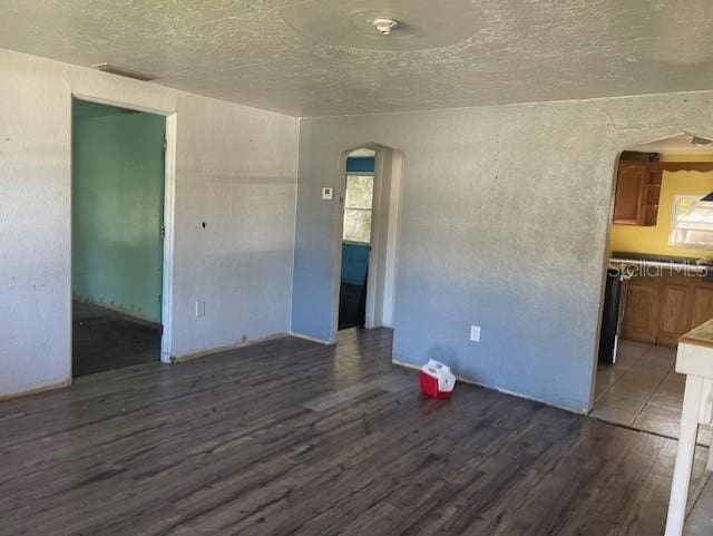 unfurnished room featuring a textured ceiling and dark wood-type flooring