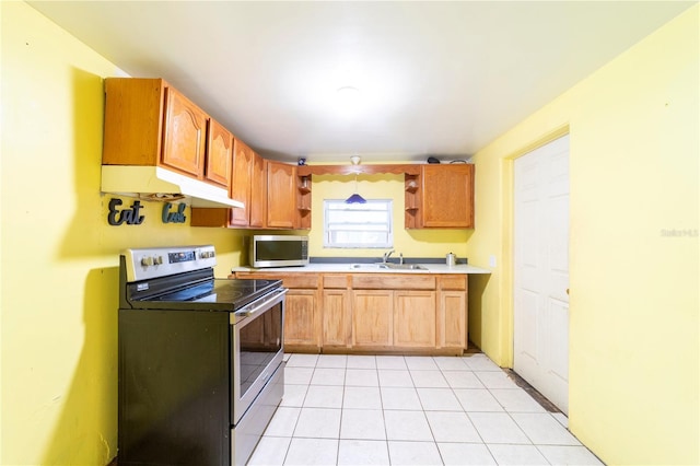 kitchen featuring stainless steel appliances, sink, and light tile patterned floors