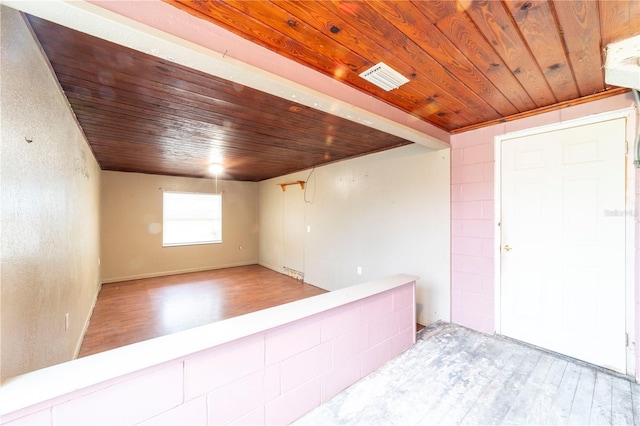 unfurnished room featuring light wood-type flooring and wooden ceiling