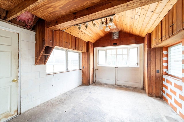 empty room with wood ceiling, plenty of natural light, and vaulted ceiling