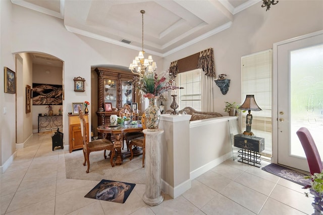 dining area with light tile patterned flooring, a raised ceiling, crown molding, and an inviting chandelier