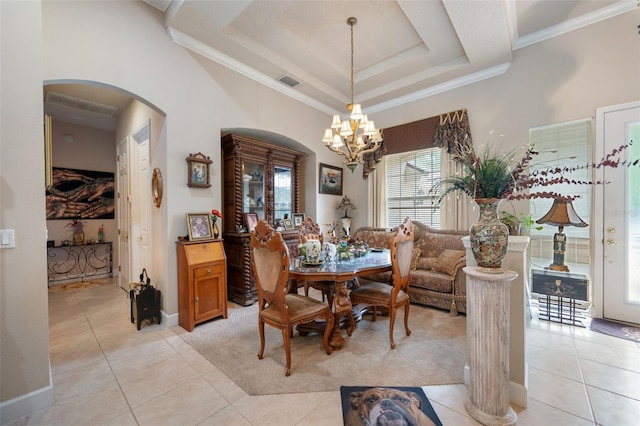 tiled dining area featuring ornamental molding, a tray ceiling, and a notable chandelier