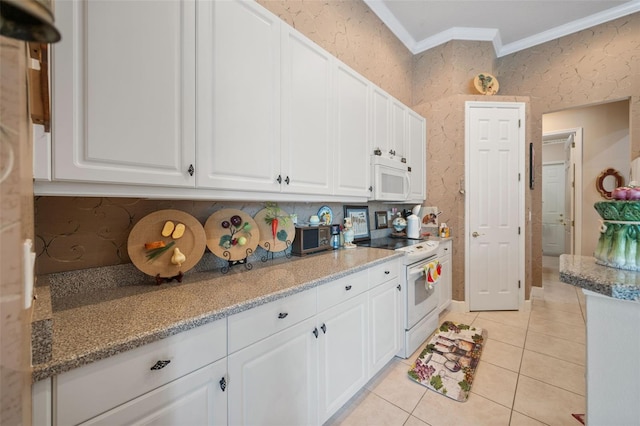 kitchen featuring light stone countertops, light tile patterned flooring, white appliances, white cabinets, and ornamental molding