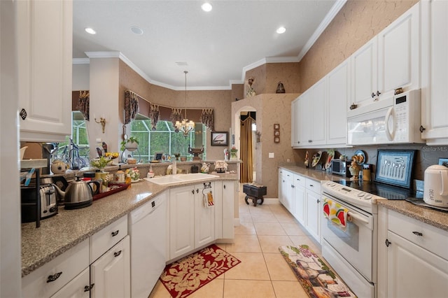 kitchen with white appliances, crown molding, pendant lighting, an inviting chandelier, and white cabinets