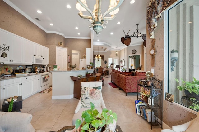 kitchen with white appliances, hanging light fixtures, light tile patterned floors, and an inviting chandelier