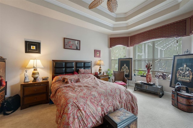 carpeted bedroom with ceiling fan, a raised ceiling, and crown molding