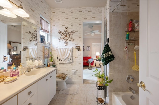 full bathroom with ceiling fan, crown molding, toilet, vanity, and tiled shower / bath