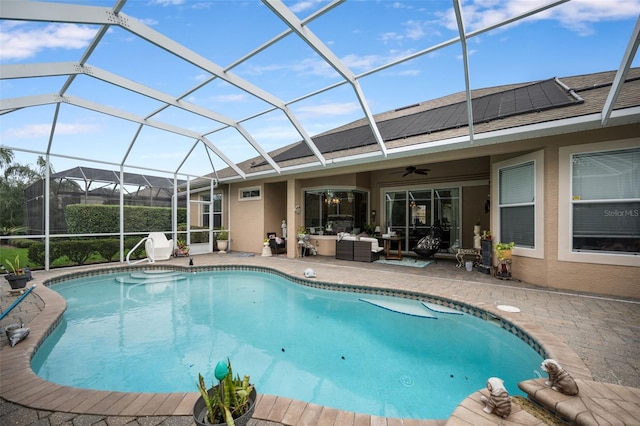 view of pool featuring outdoor lounge area, ceiling fan, a patio area, and glass enclosure