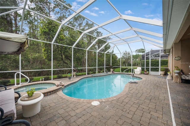 view of pool with a patio area, an in ground hot tub, and glass enclosure