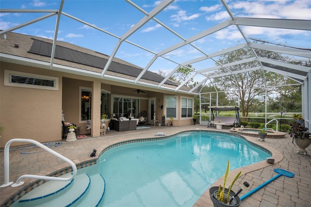 view of swimming pool with glass enclosure, an in ground hot tub, a patio, and an outdoor hangout area